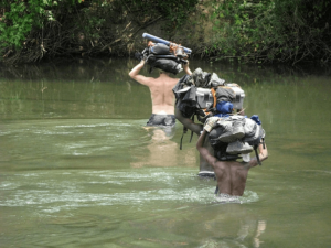Teams protecting samples and kits as they cross a river in Central Africa